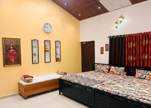 a bedroom with a bed and a clock on the wall at Madhuson Palms in Karjat