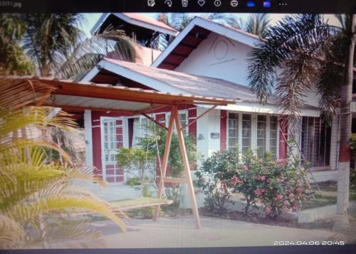 a small white house with a porch and a bench in front at Madhuson Palms in Karjat
