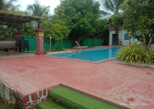 a swimming pool in a yard with a house at Madhuson Palms in Karjat