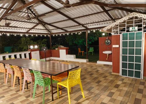 a patio with a table and chairs and a kitchen at Madhuson Palms in Karjat