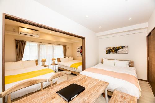 a hotel room with two beds and a table at Tomariehoteru & kondominiamu - Vacation STAY 19480v in Hakata