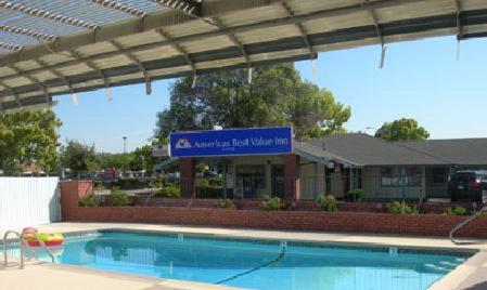 a swimming pool in front of a building with a sign at Americas Best Value Inn - Livermore in Livermore