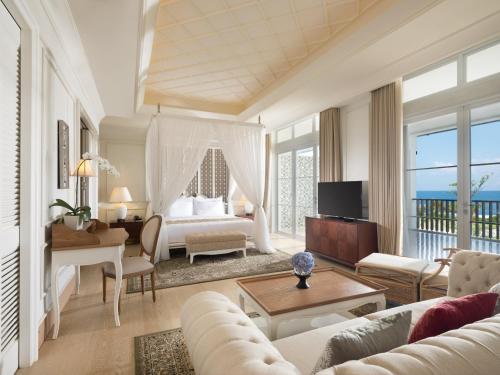 a living room with a bedroom with a bed and a table at Rumah Luwih Bali in Keramas
