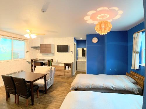 a bedroom with blue walls and a table and a dining room at Alaula - Vacation STAY 22838v in Izumi-Sano