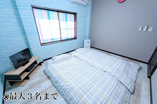 a bedroom with a bed and a window at STEP by STEP - Vacation STAY 25753v in Kanayama