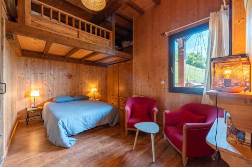 a bedroom with a bed and two chairs at L'Escampette à la Fontanette in Saint-Pancrace