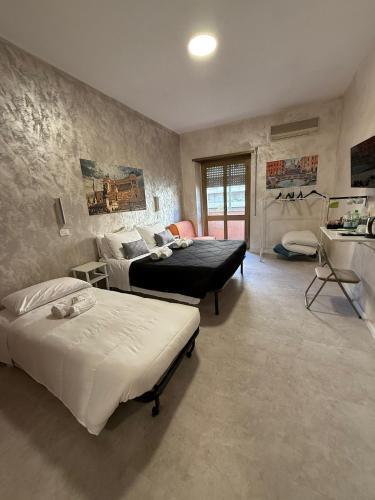 a bedroom with two beds and a table and a desk at Appio Rooms Haven in Rome