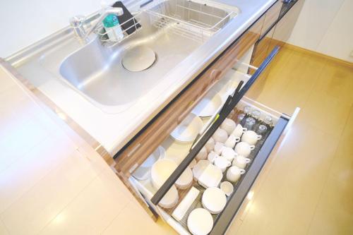 an open refrigerator with a sink and a bunch of dishes at Wataru DUO - OKINAWA - Vacation STAY 26735v in Inbu