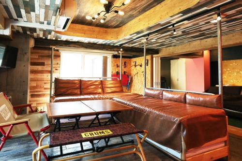 a living room with a leather couch and a table at Lions Mansion Sapporo Jozankei Sanbankan - Vacation STAY 10916 in Jozankei