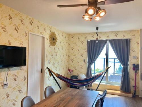 Pokój ze stołem i hamakiem na ścianie w obiekcie HOKOHOUSE - Vacation STAY 26880v w mieście Yaka