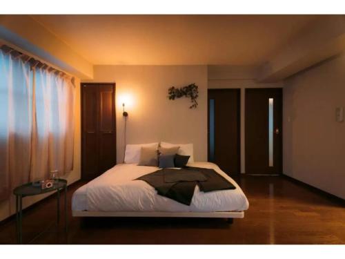 a bedroom with a large bed and a window at gate nagasaki stay&green - Vacation STAY 27220v in Nagasaki