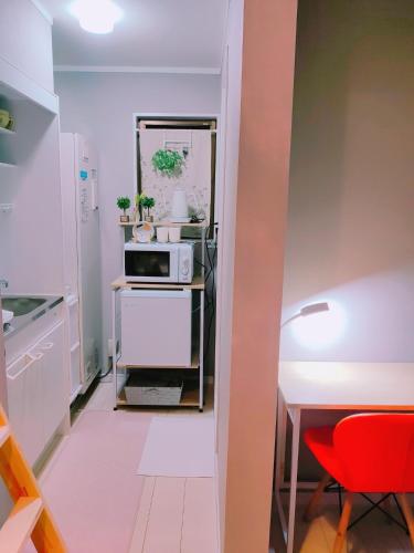 a small kitchen with a table and a microwave at MeMe Inn - Vacation STAY 10900 in Saitama