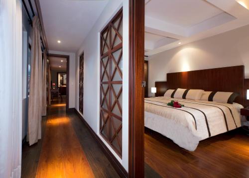1 dormitorio con 1 cama grande y pasillo en Gran Colombia Suites, en Cuenca