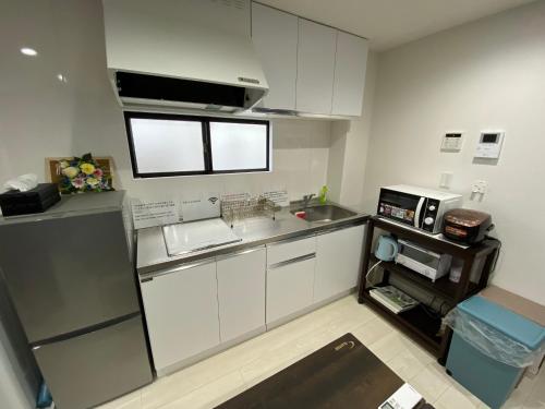 a small kitchen with a sink and a microwave at Wonderful stay TOKYO - Vacation STAY 30862v in Tokyo