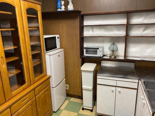 a kitchen with a refrigerator and a microwave at Ise Toyohama Villa - Vacation STAY 11133 in Ise