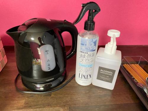 a tea kettle and a bottle of liquid on a table at STEP by STEP - Vacation STAY 25756v in Kanayama