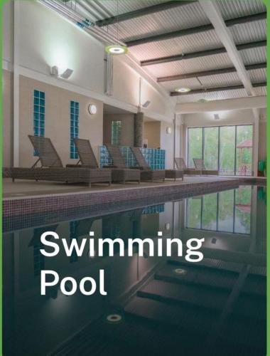 a swimming pool with chairs and the words swimming pool at Larch View in Tattershall