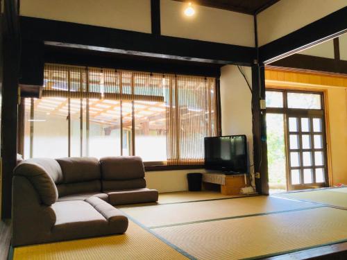 a living room with a couch and a tv at Kominkayado Netsuki no ii Kitsune - Vacation STAY 27812v in Shimanto