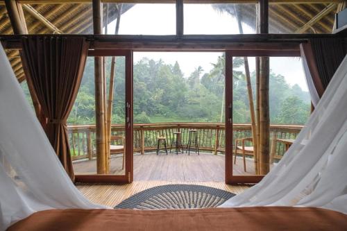 a view of a room with a bed and a balcony at Keuma Villa & Resto Jatiluwih by The Lavana in Jatiluwih