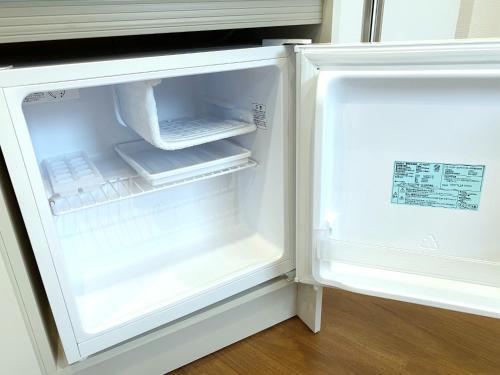 an empty refrigerator with its door open in a kitchen at SKYE HOME MINPAKU - Vacation STAY 11856 in Tokyo