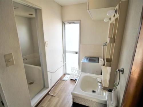 ein Badezimmer mit Waschbecken, Dusche und Spiegel in der Unterkunft Maison Ota Building A Building B - Vacation STAY 11098 in Takamatsu