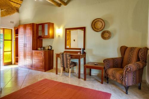 a living room with a desk and a chair at Kubu Safari Lodge in Hoedspruit