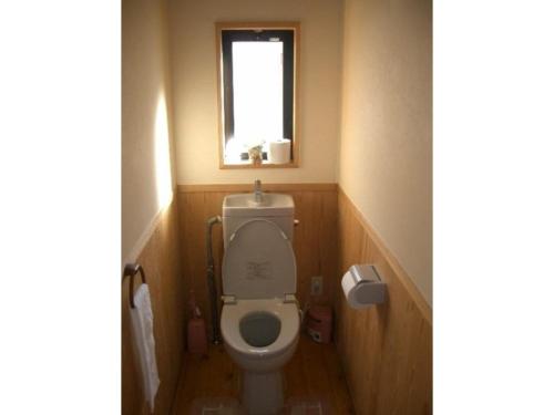 a small bathroom with a toilet with a window at Log house for 12 people - Vacation STAY 35069v in Minamioguni