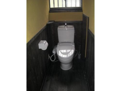 a white toilet in a bathroom with a window at Log house for 12 people - Vacation STAY 35072v in Minamioguni