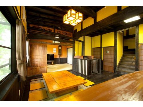 a large room with a wooden table in a building at Log house for 12 people - Vacation STAY 35072v in Minamioguni