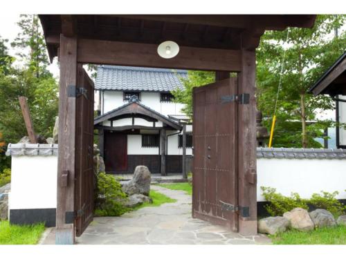 an entrance to a building with a wooden gate at Log house for 12 people - Vacation STAY 35072v in Minamioguni