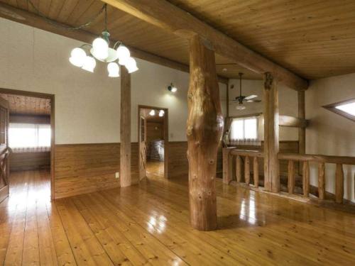 a large room with wooden floors and a wooden pole at Log house for 12 people - Vacation STAY 33957v in Minamioguni