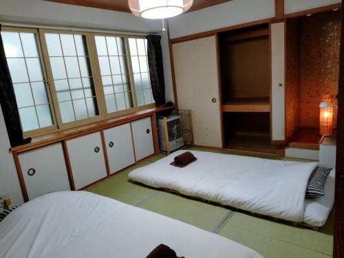 two beds in a room with windows at Bay View House - Vacation STAY 17471 in Otaru