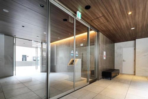 an office lobby with glass doors and a wooden ceiling at A,T,HOTEL HAKATA - Vacation STAY 36414v in Fukuoka