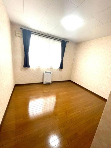 an empty room with a large window and a wooden floor at Avidasion - Vacation STAY 12038 in Biei