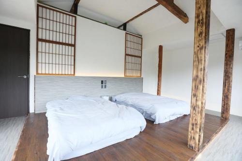 two beds in a room with wooden poles at Sani no Teitaku - Vacation STAY 36110v in Amami