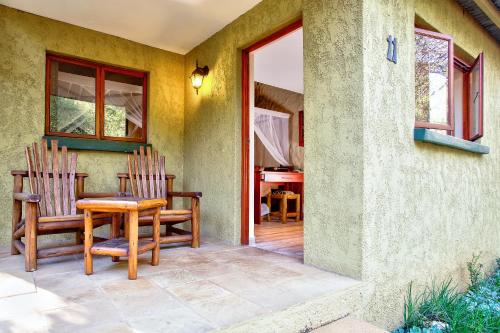 a patio with two chairs and a table at Kubu Safari Lodge in Hoedspruit
