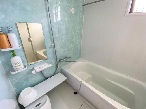 a bathroom with a tub and a toilet and a sink at Yonehara Beach Stay LUANA - Vacation STAY 38711v in Fukai