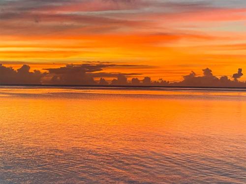 an orange sunset over the water with clouds at Yonehara Beach Stay LUANA - Vacation STAY 38711v in Fukai