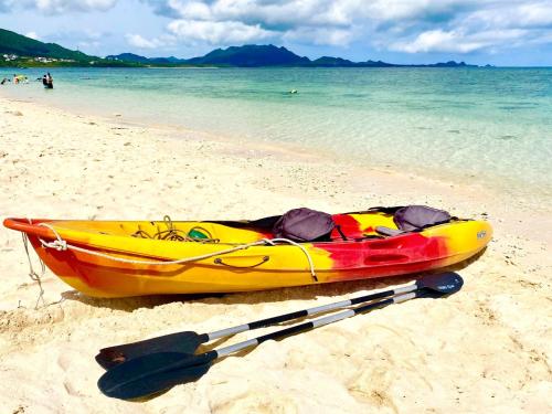 a yellow kayak sitting on the beach with a paddle at Yonehara Beach Stay LUANA - Vacation STAY 38711v in Fukai