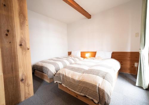 two beds in a bedroom with white walls at Chamonix - Vacation STAY 67793v in Iiyama