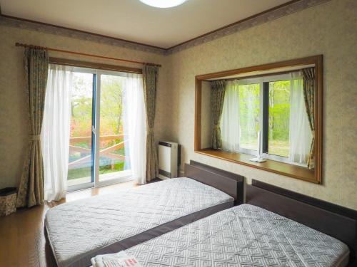 a bedroom with a bed and two windows at Rigeru - Vacation STAY 11338 in Nasu