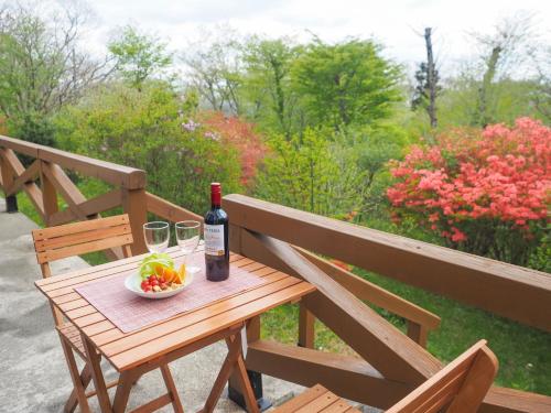 a wooden table with a bottle of wine and a bowl of fruit at Rigeru - Vacation STAY 11338 in Nasu