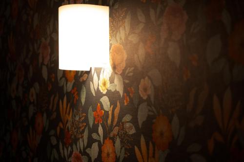 a lamp with a flower pattern on a wall at Tabi no yado Hanakeshiki Botan 4th floor - Vacation STAY 43035v in Yufuin