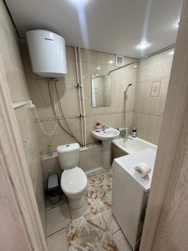 a bathroom with a toilet and a sink at Абдирова 19 в центре in Karagandy