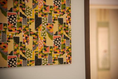 a picture of a quilt hanging on a wall at Tabi no yado Hanakeshiki Nanohana 1st floor - Vacation STAY 42962v in Yufuin