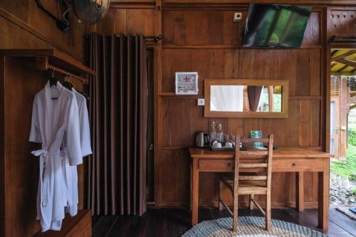 a wooden room with a desk and a mirror at Keuma Villa & Resto Jatiluwih by The Lavana in Jatiluwih