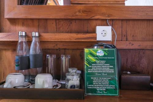 a shelf with two bottles and a sign on it at Keuma Villa & Resto Jatiluwih by The Lavana in Jatiluwih