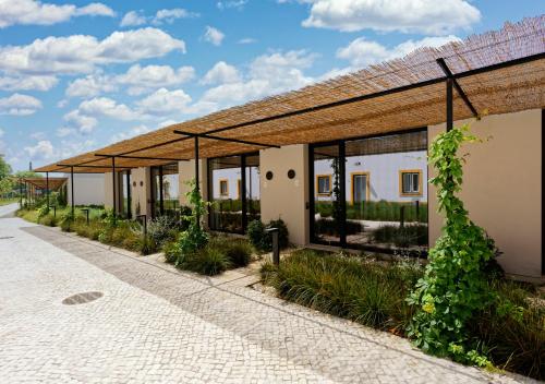 a building with a row of windows and plants at Montebelo Vista Alegre Ílhavo Hotel in Ílhavo