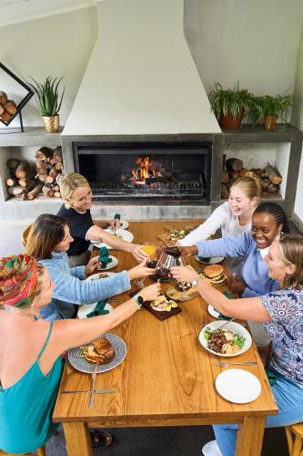 a group of people sitting around a table eating food at Hotel Olivewood in East London
