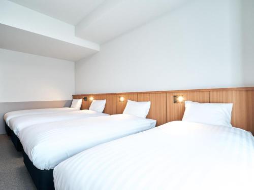two beds in a room with white sheets at Rakuten STAY Naha Yachimun Street - standard 5 Bed Room in Naha
